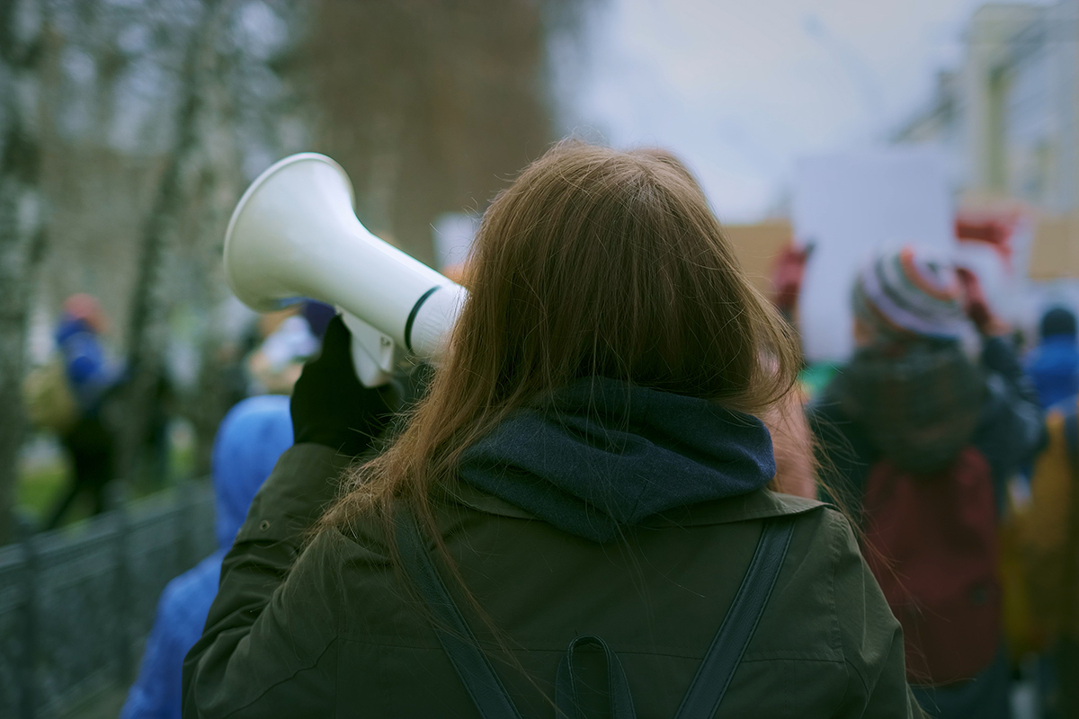 closeup of the back of the head of a woman holding a megaphone
